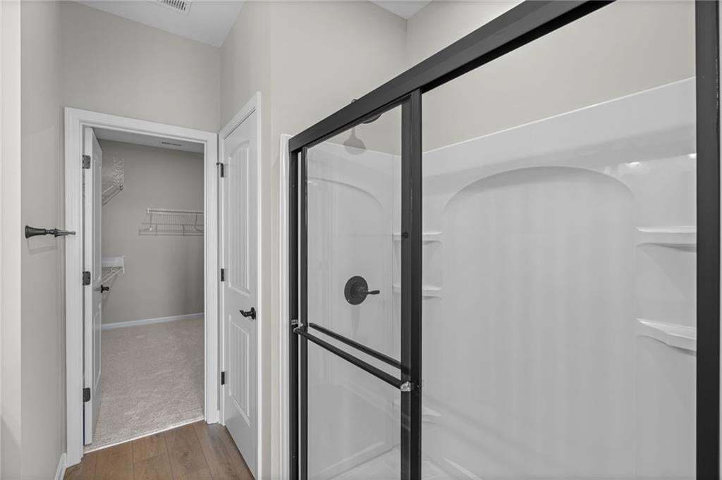 Shower enclosure with black-framed glass sliding doors, integrated shelving, and a matte black shower fixture