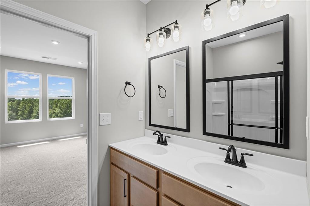 Double vanity with white countertops, undermount sinks, and matte black fixtures