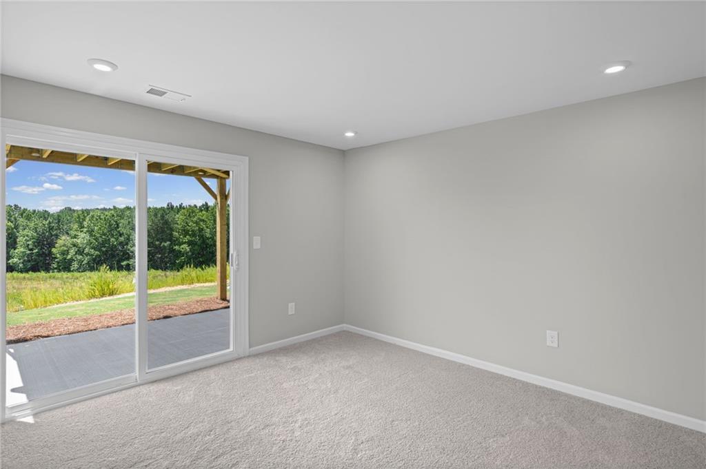 Sliding glass door leading to an outdoor patio with a natural landscape