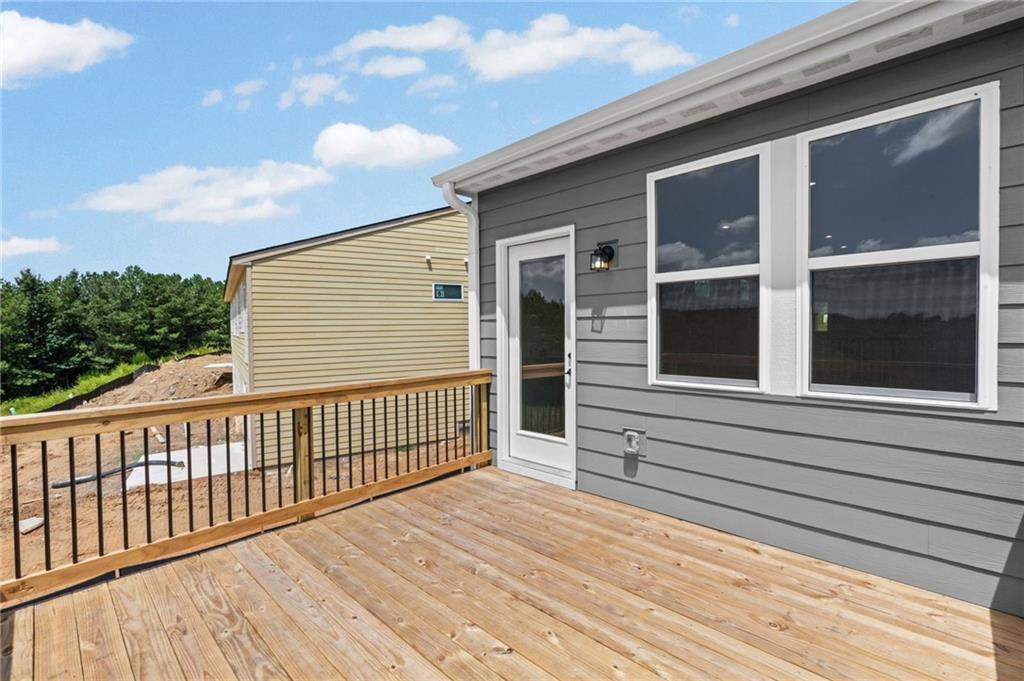 Outdoor deck with wood-finish flooring, wood railings, and black balusters