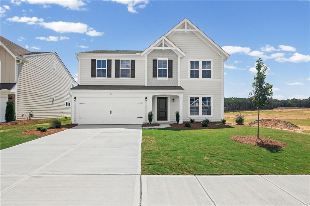 Two-story property with light-toned siding, dark shutters, and a two-car garage