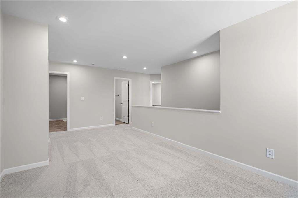 Recessed lighting, light gray wall finishes, light carpeting, and white trim