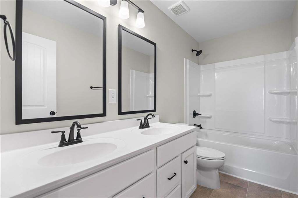 Dual vanity with undermount sinks, matte black fixtures, and a white countertop