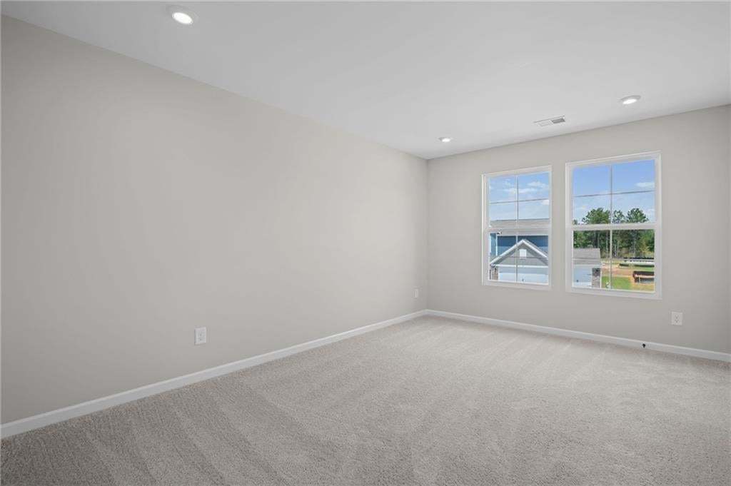 Recessed lighting, light gray wall paint, and gray carpeting