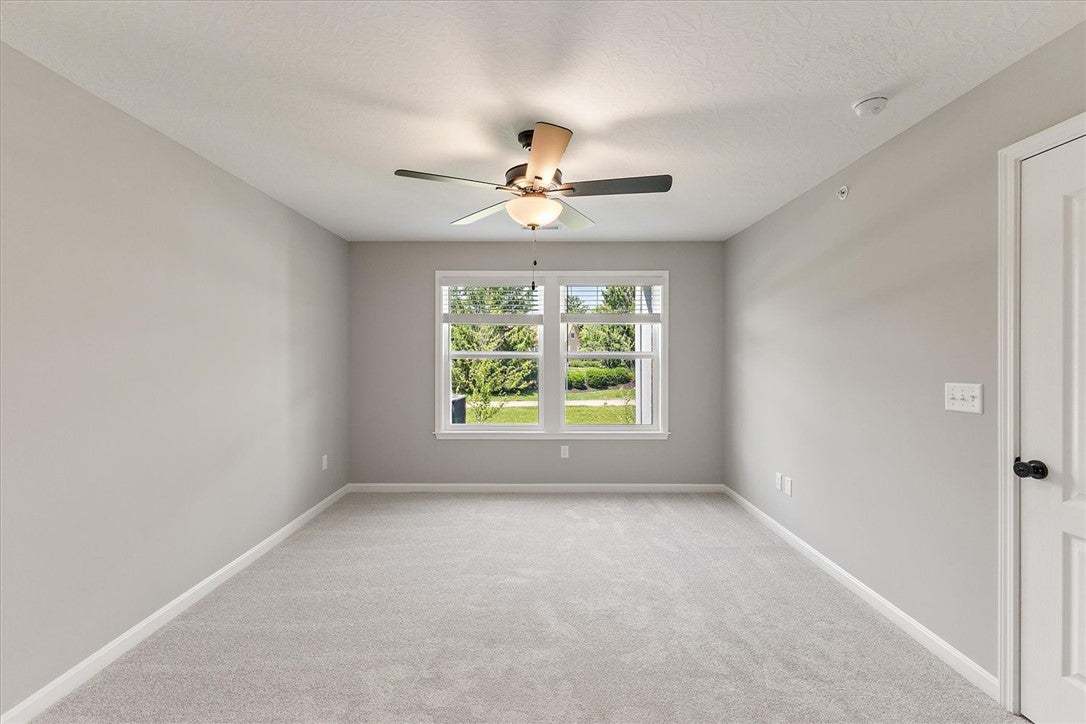 A well-proportioned bedroom with carpeting and a w