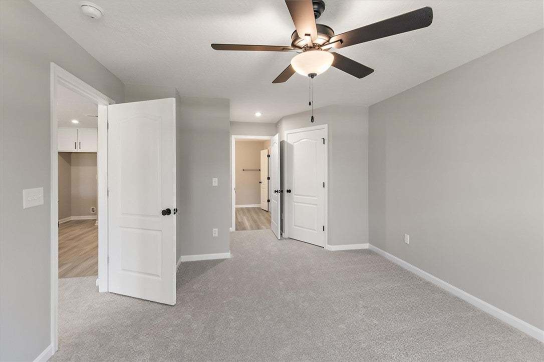This bedroom offers ample space with plush carpeti
