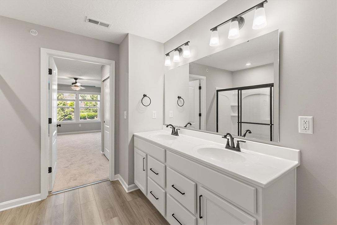 This primary bathroom features a dual vanity, slee