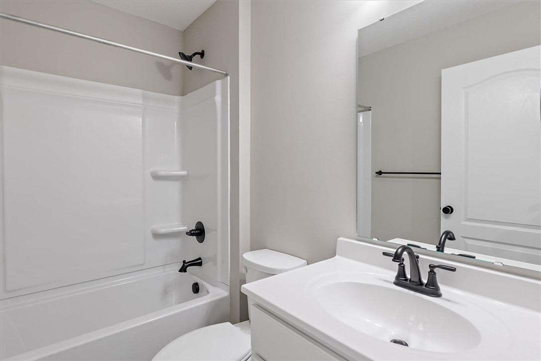 This primary bathroom features a white vanity with