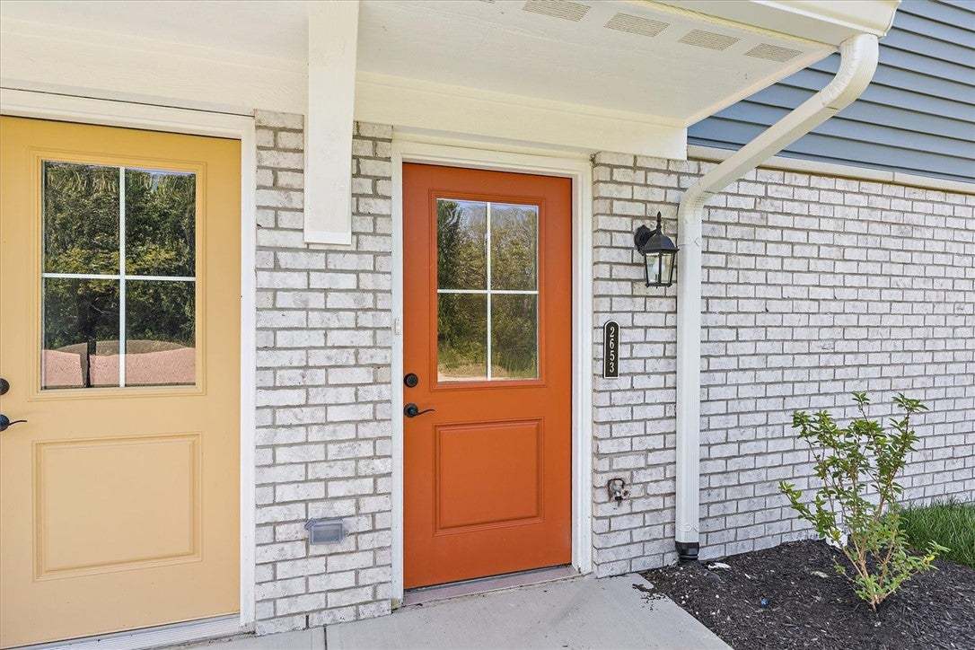 A vibrant orange door provides a striking welcome