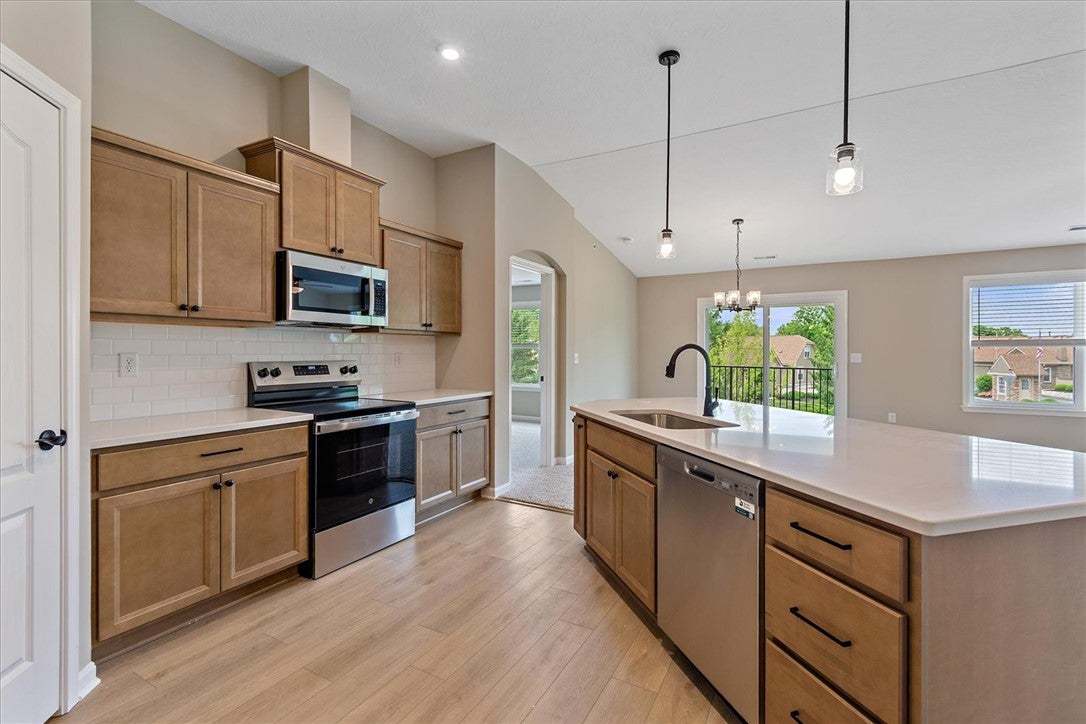This kitchen showcases light wood cabinetry, prist