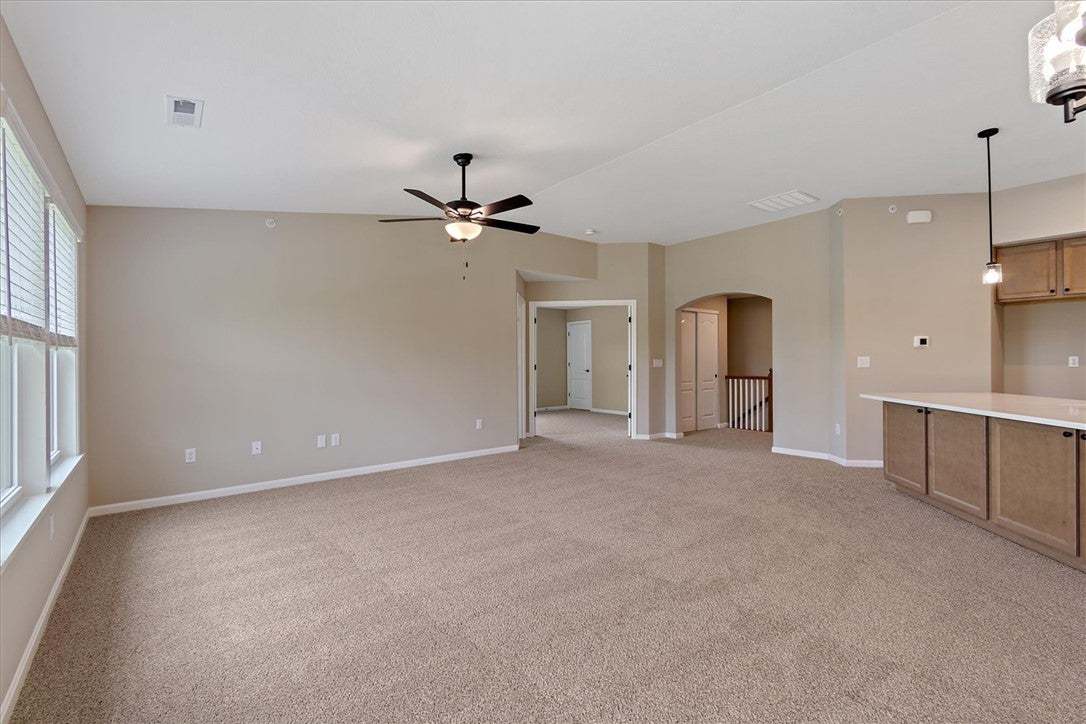 A spacious, carpeted living area features a kitche