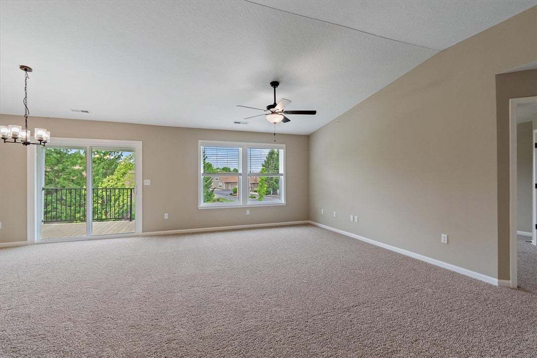 A spacious living area featuring plush carpeting a