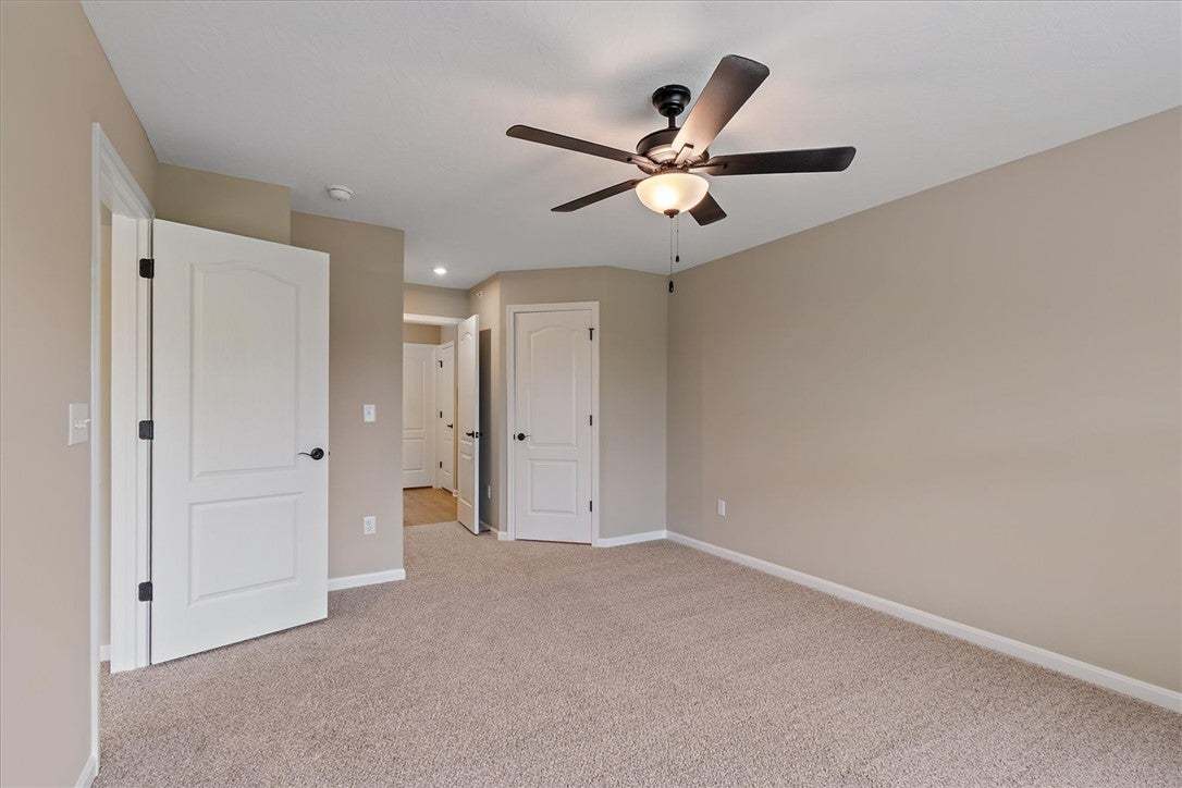 This generous bedroom features plush carpeting and