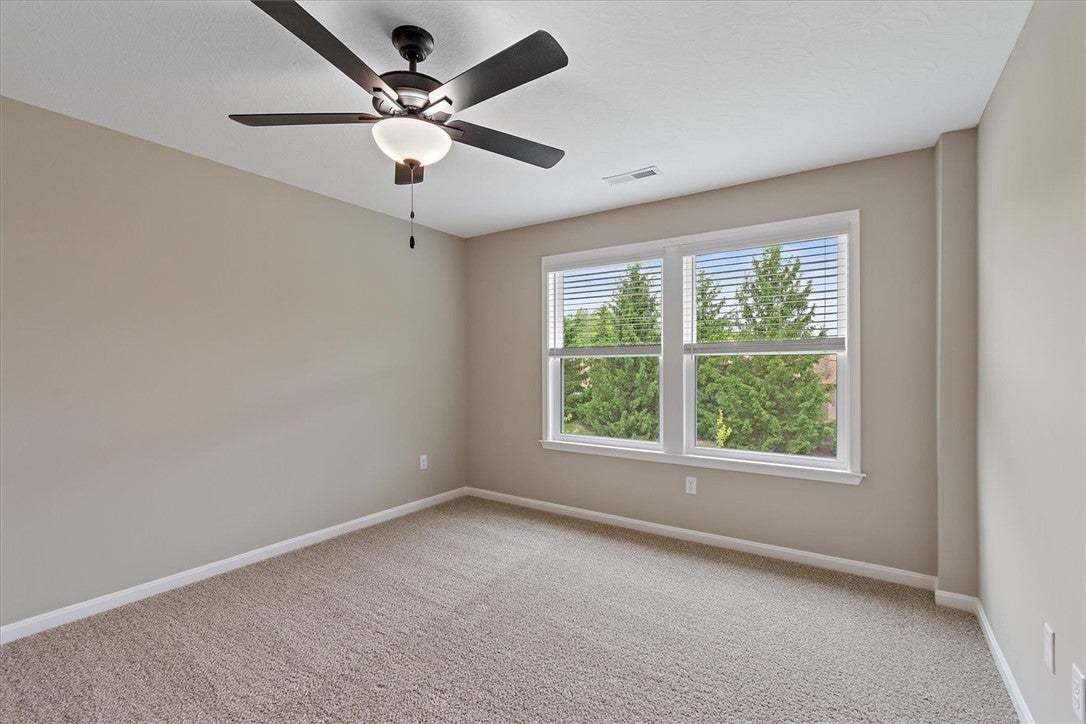 This peaceful bedroom boasts wall-to-wall carpetin