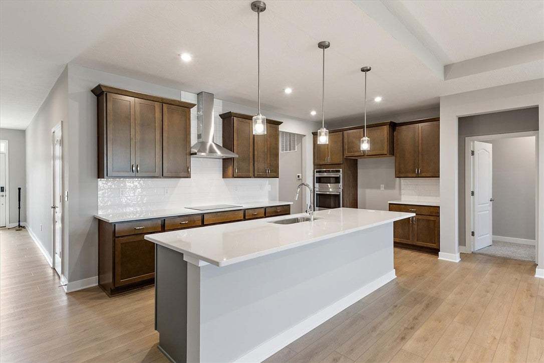 This kitchen showcases a central island, rich cabi