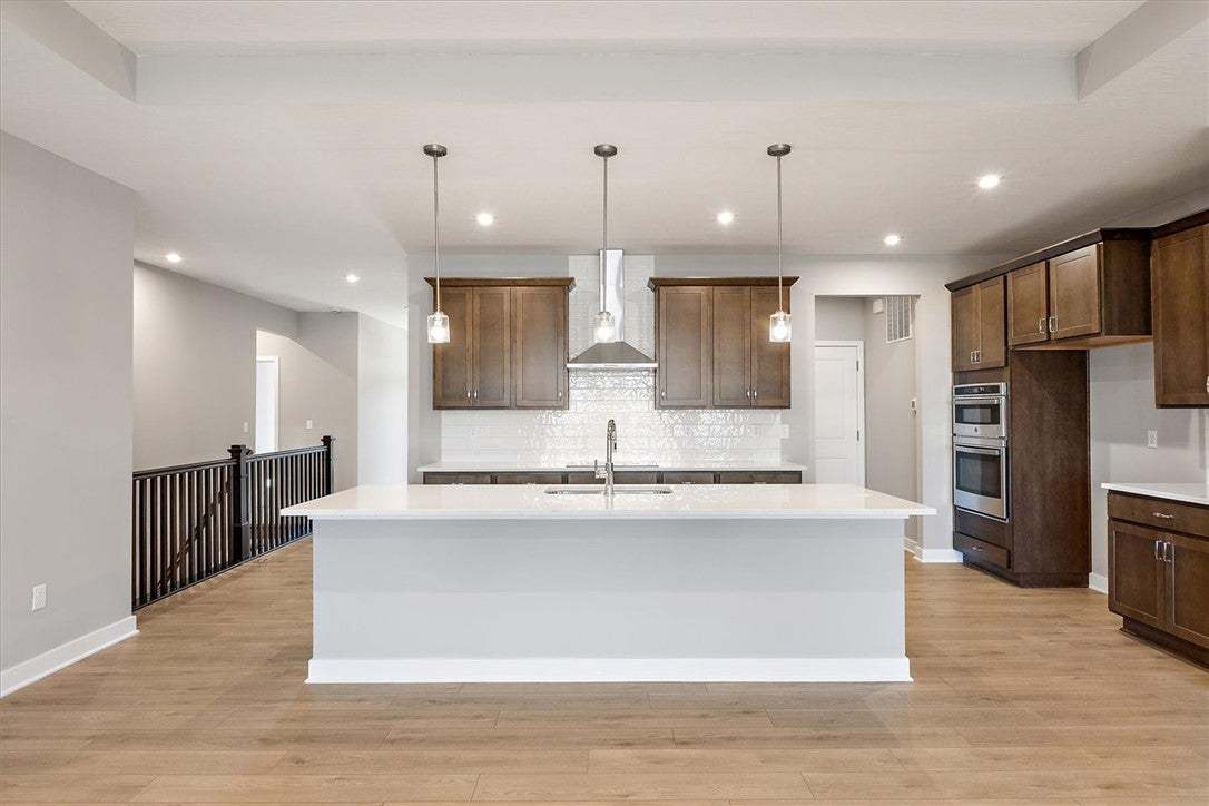 A well-lit kitchen boasts warm wood cabinetry, a b