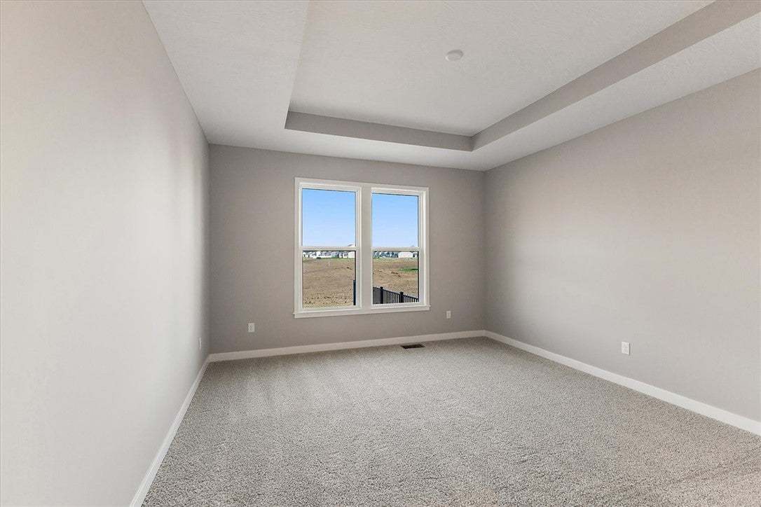 This primary bedroom features a modern tray ceilin
