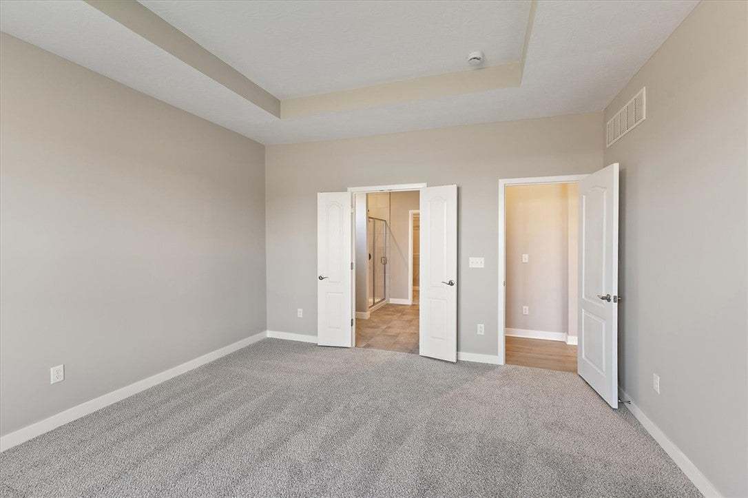 A spacious primary bedroom features soft carpeting