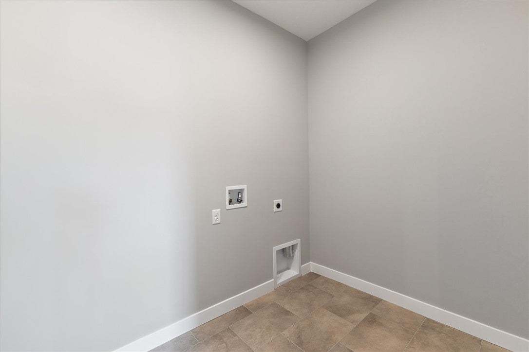 This dedicated laundry space features practical ti