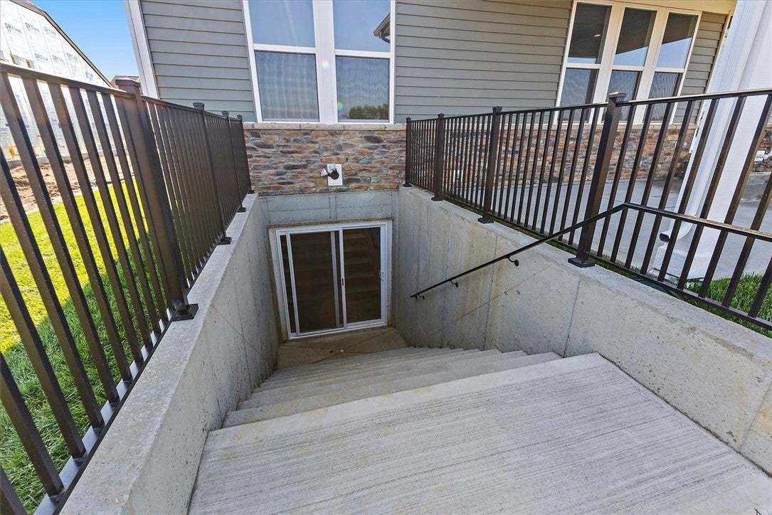 Concrete steps lead down to a basement entrance wi