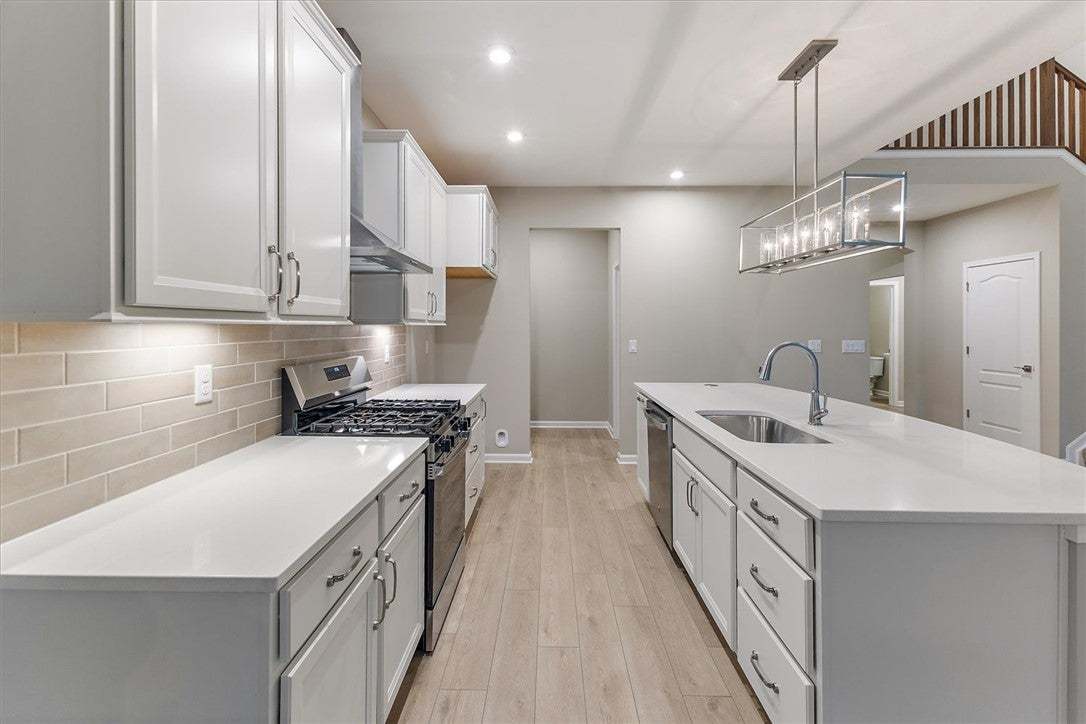 Streamlined cabinetry and quartz countertops frame
