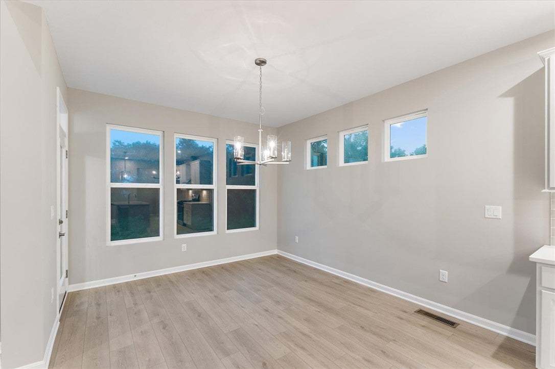 A spacious dining area boasts rich wood-style floo