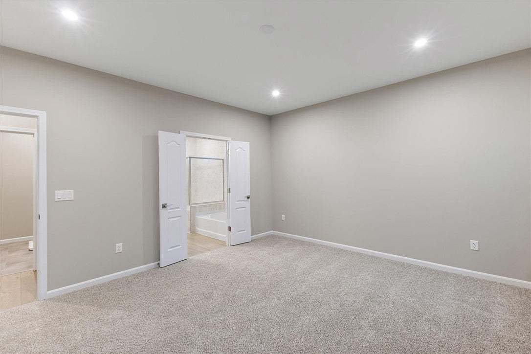 Double doors open to reveal an adjacent bathroom f