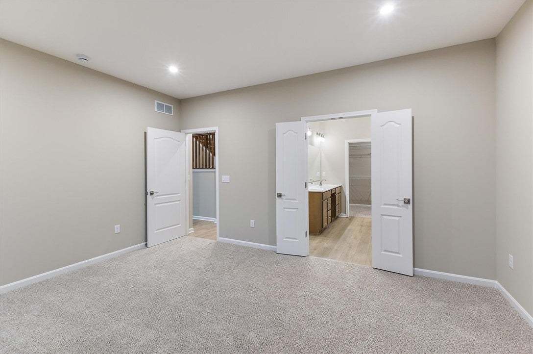 Plush carpeting underfoot anchors a spacious bedro