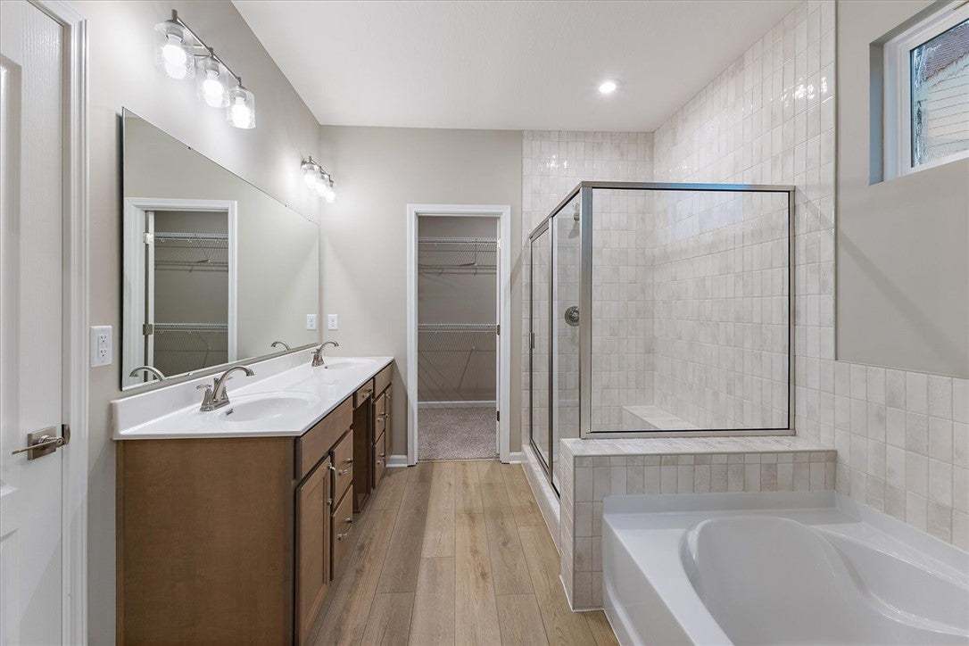 A spacious layout showcases a double vanity, glass