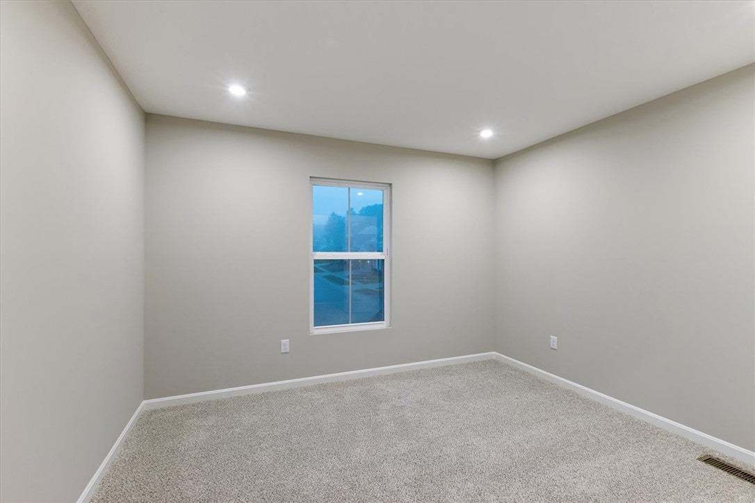 Plush carpeting and modern recessed lighting defin