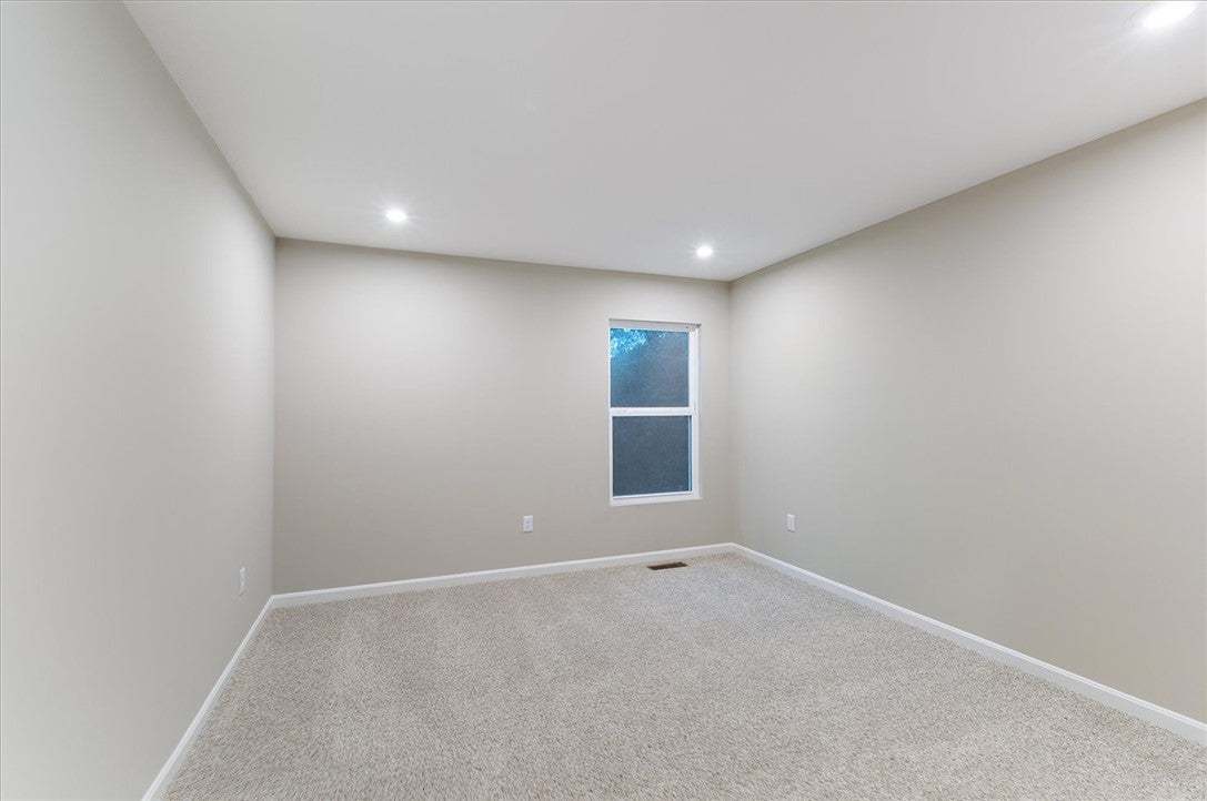 Plush carpeting and recessed lighting create a com