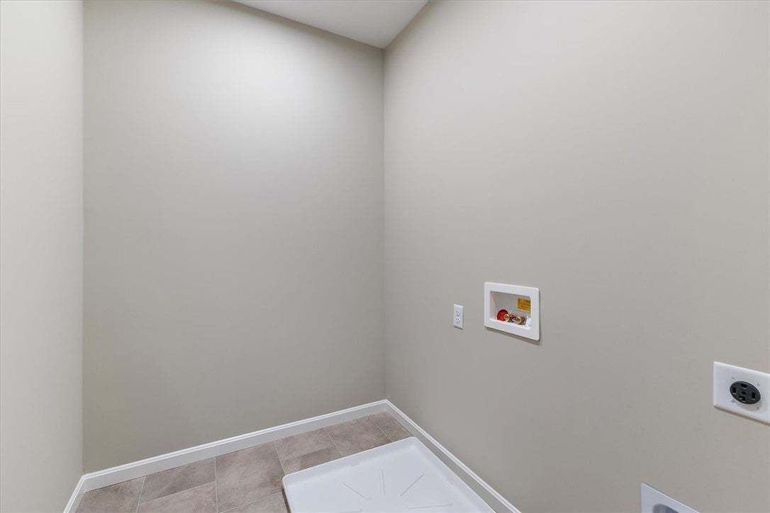 A dedicated laundry space features durable tile fl
