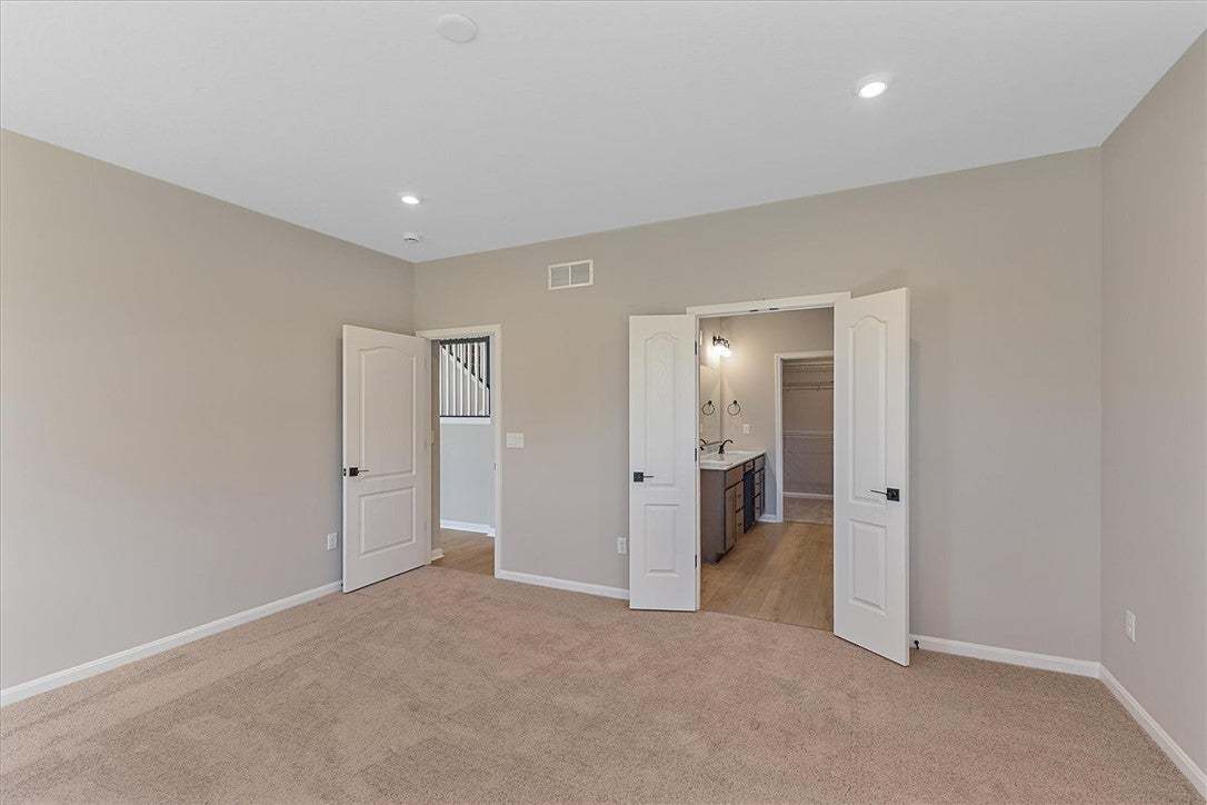 This spacious bedroom offers carpet flooring and d