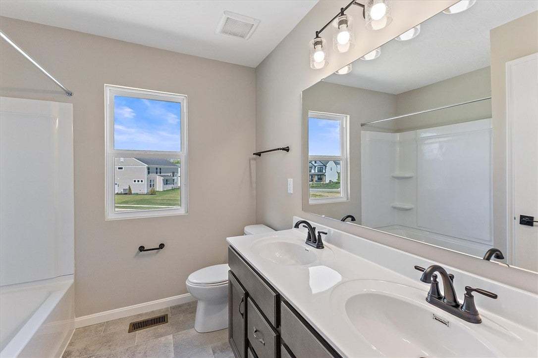 This modern bathroom features a dual vanity and sl