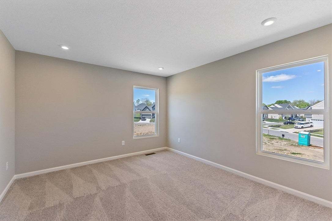 This bright, carpeted room offers ample natural li