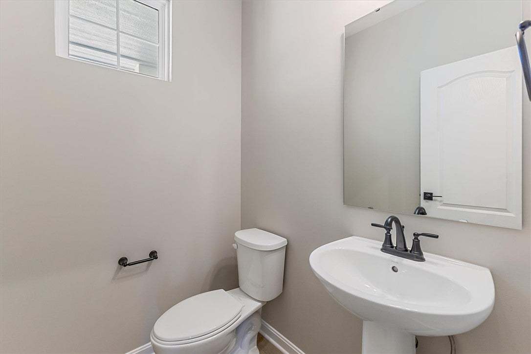 This clean and bright powder room features a pedes
