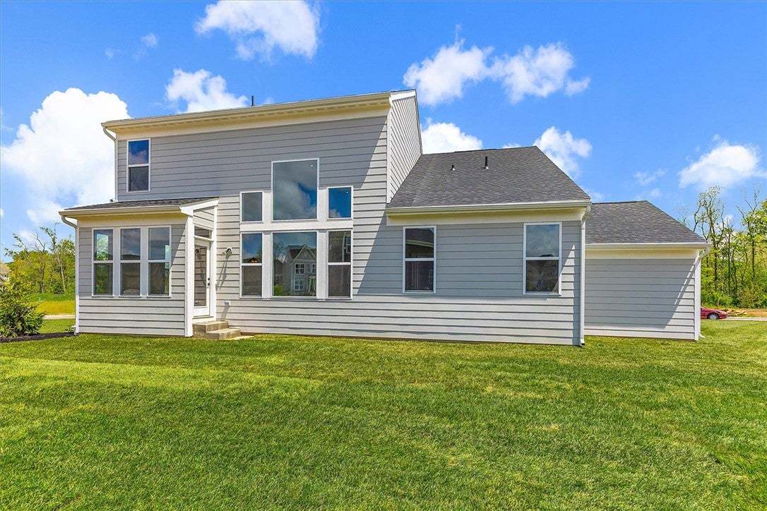 This residence showcases a well-maintained yard an