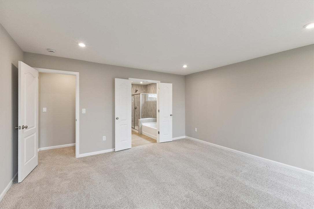 This spacious primary bedroom offers plush carpeti
