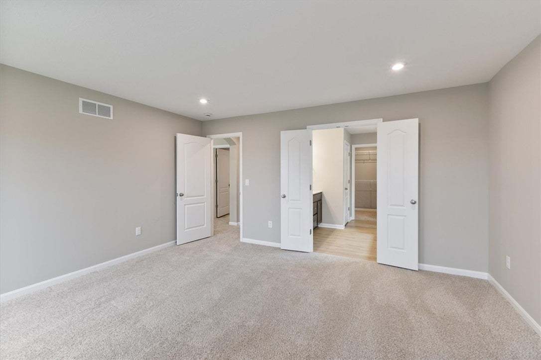 This spacious bedroom offers comfortable carpeting