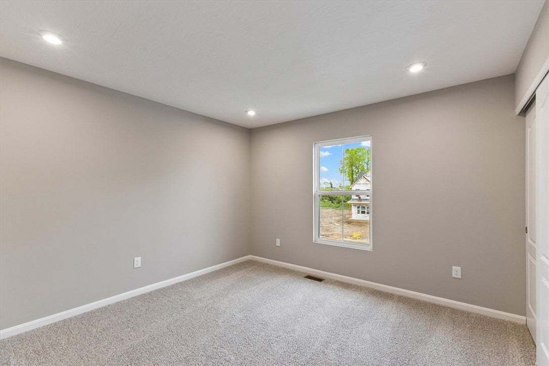 This cozy bedroom features plush carpeting and abu