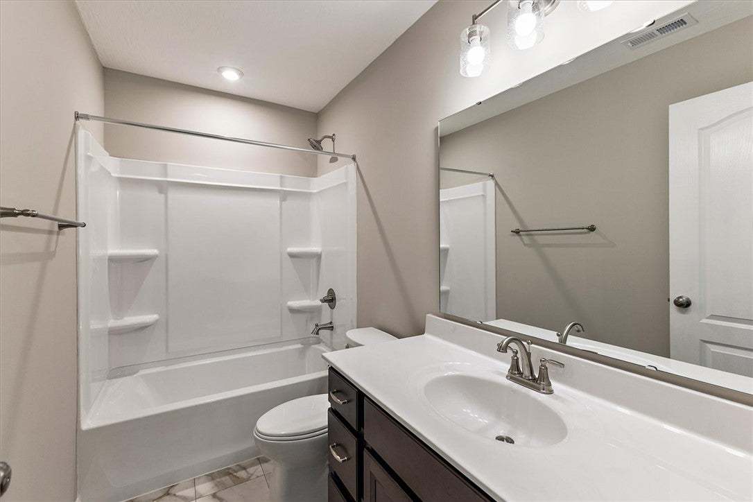 This bright bathroom features a spacious tub and s