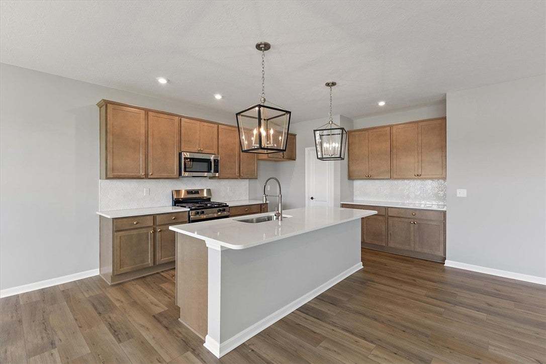 A contemporary kitchen showcasing wood floors, whi