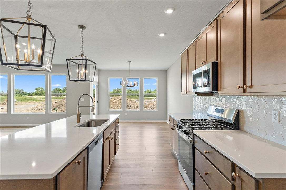 A pristine kitchen boasts stainless steel applianc