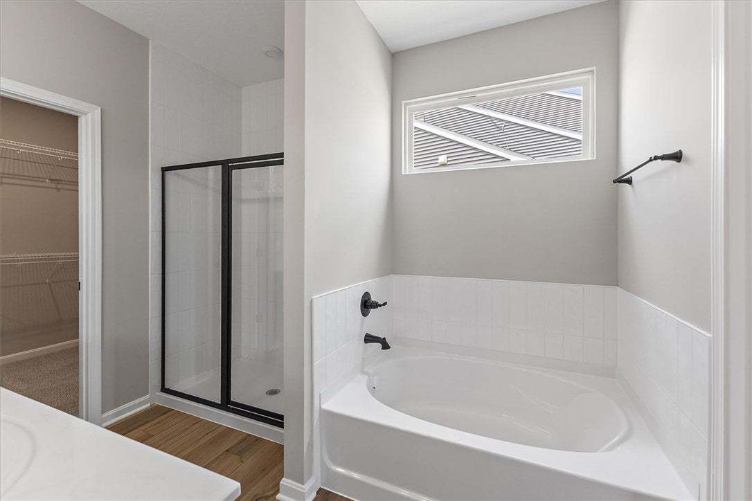A well-lit primary bathroom with a modern soaking