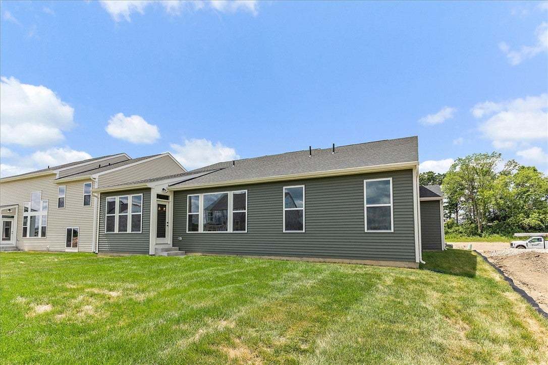 Green siding defines the back of this home, comple