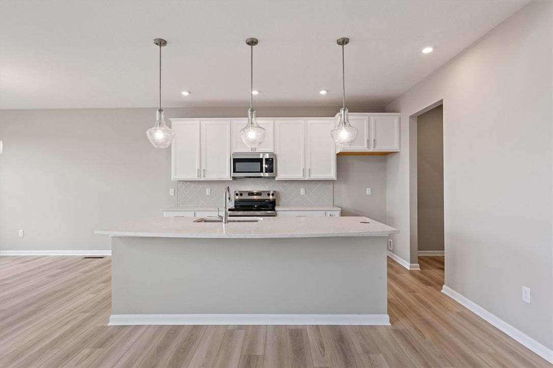 This bright kitchen features an expansive island a