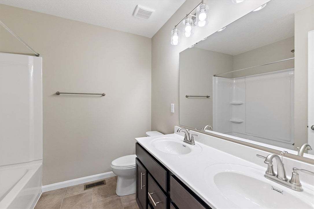 This functional bathroom features a dual vanity an