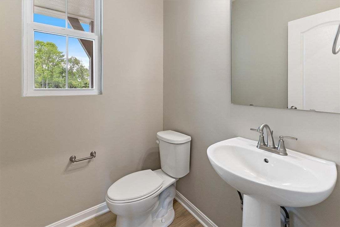This bright bathroom features a pedestal sink and