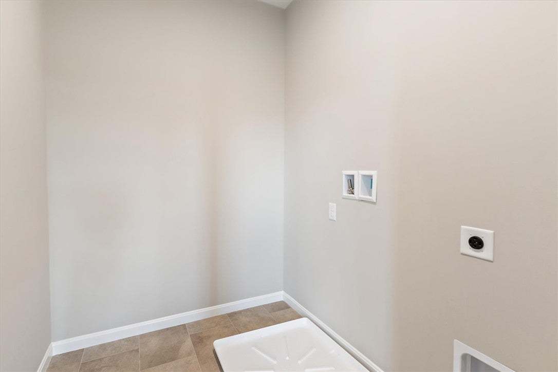 This dedicated laundry space features practical ti