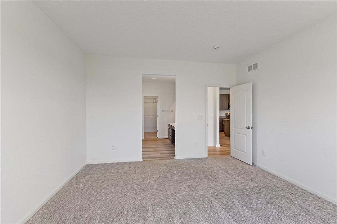 A spacious room offers comfortable carpeting, with